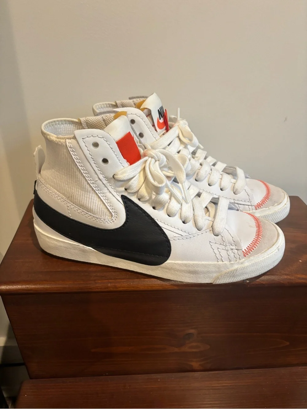 Nike White High-Top Sneakers with Black Swoosh and Orange Tongue Tab